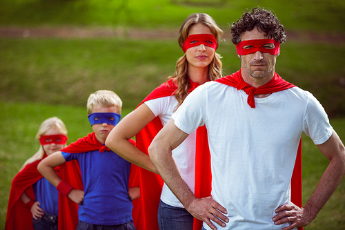 Happy family pretending to be superhero in the park