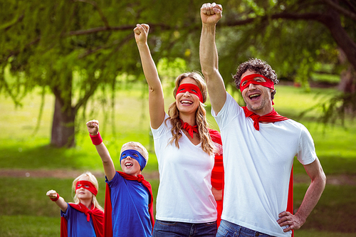 Happy family pretending to be superhero in the park