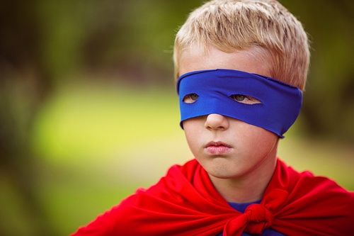 Little boy pretending to be superhero in park