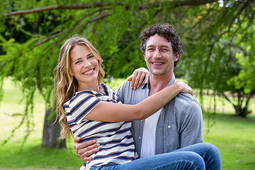 Husband carrying his wife in park