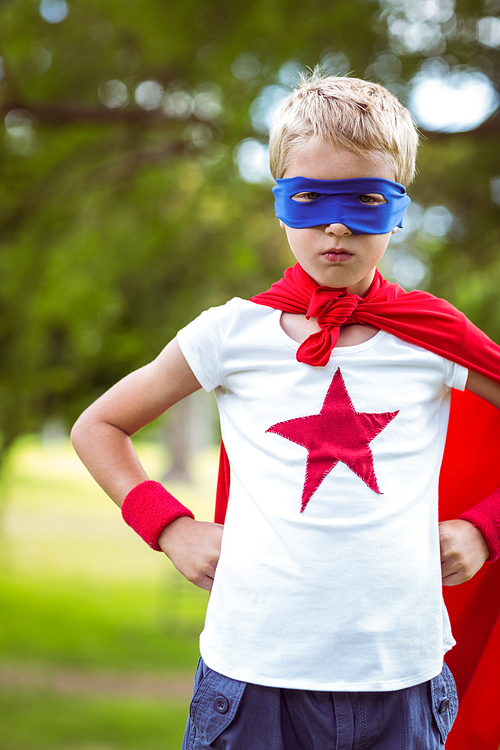 Little boy pretending to be superhero in park