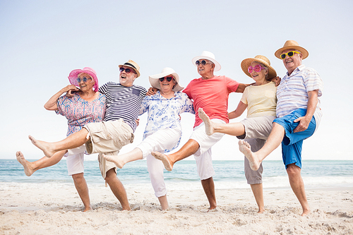 Happy senior friends dancing on the beach