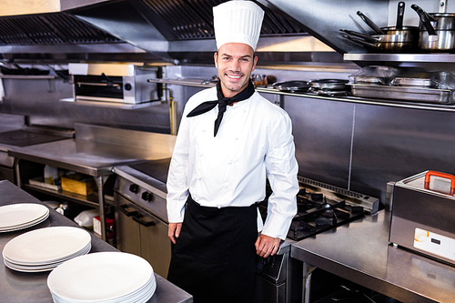 Portrait of happy male chef standing in kitchen