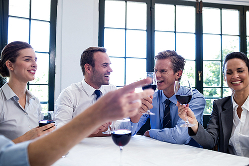 Group of businesspeople toasting wine glass during business lunch meeting in a restaurant