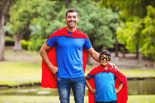 Father and son in superhero costume standing in park