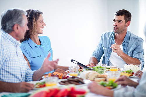 Happy family talking while having breakfast at home