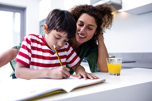 Mother helping son with homework in kitchen