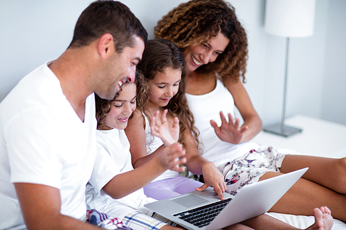 Family having video chat on laptop at home