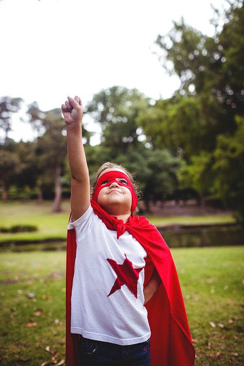 Girl in superhero costume posing in park