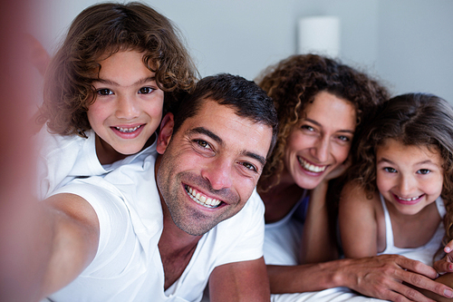 Portrait of happy family lying on bed at home