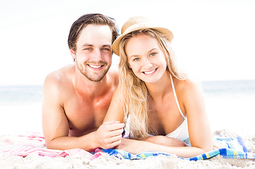 Portrait of young couple lying on the beach on a sunny day