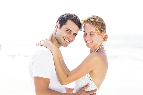 Young couple embracing on the beach on a sunny day