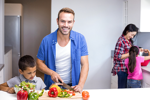 Happy family in the kitchen chopping vegetables at home
