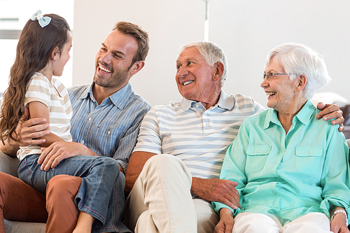 Portrait of happy family sitting on sofa in their living room