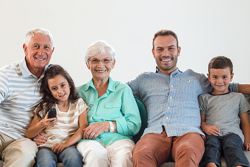 Happy family sitting on sofa watching television in their living room