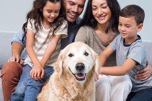 Family petting dog in living room