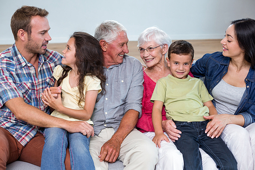 Family sitting on sofa and interacting with each other in living room