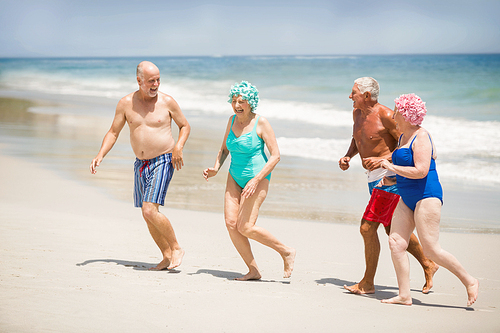 Seniors running at the beach on a sunny day