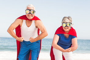 Senior couple wearing superman costume on a sunny day