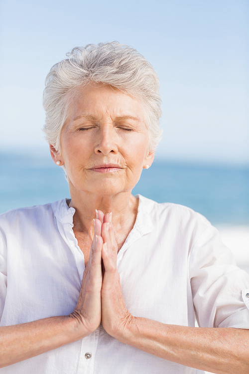 Senior woman relaxing on the beach on a sunny day