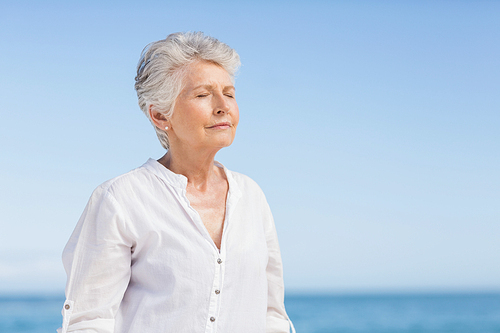 Senior woman relaxing on the beach on a sunny day