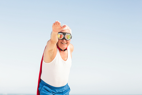 Senior man pretending to be a superhero on a sunny day