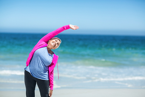 Mature woman outstretching her arms on the beach