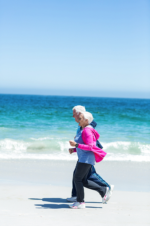 Cute mature couple running together on the beach