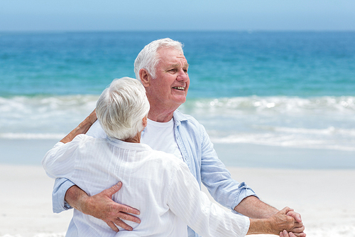 Senior couple dancing at the beach on a sunny day