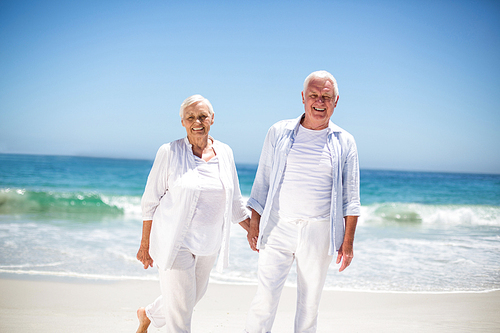 Senior couple holding hands on the beach