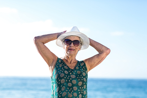 Senior woman posing with sunhat at the beach