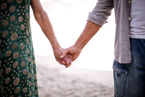 Senior couple holding hands on the beach