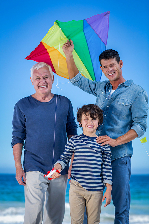 Male family members playing with a kite at the beach
