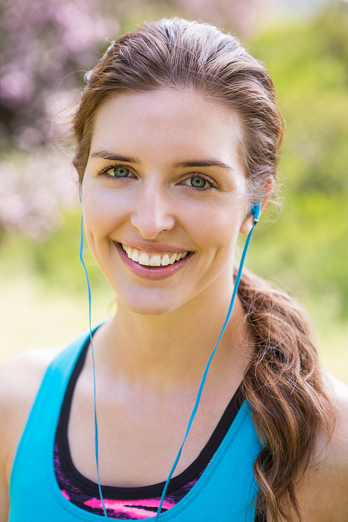 Smiling woman wearing earphones in the countryside