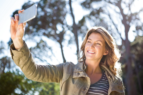 Smiling woman taking selfie in the countryside