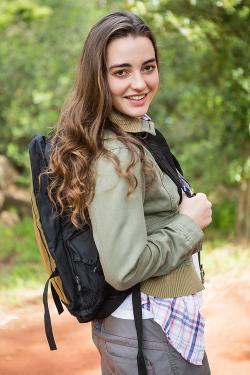 Smiling woman with backpack in the countryside