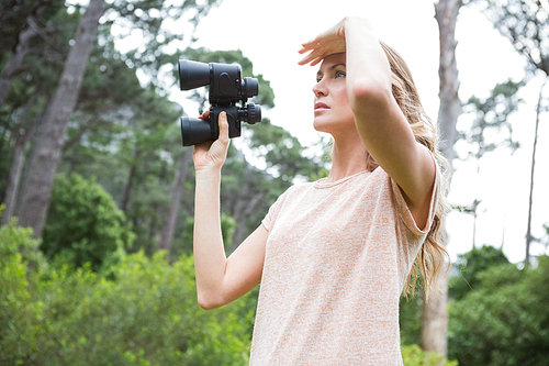 Woman using binoculars in the countryside