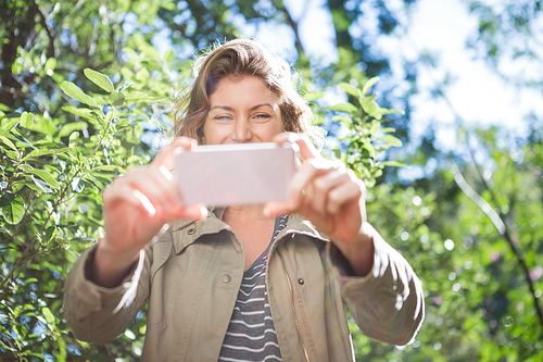 Smiling woman taking selfies in the countryside