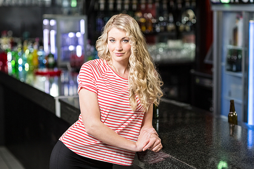Portrait of smiling blonde woman in a bar