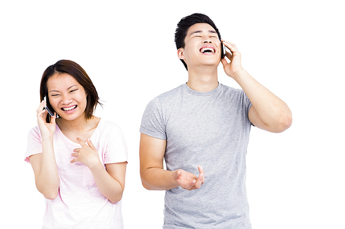 Young couple talking on mobile phone on white background