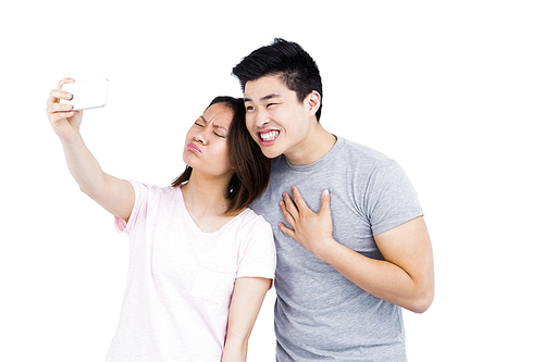 Young couple taking a selfie on smartphone on white background