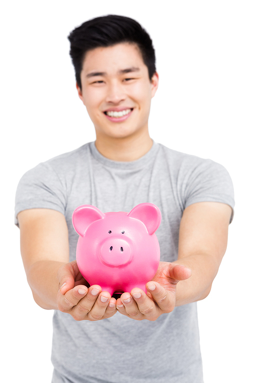 Young man holding a piggy bank on white background