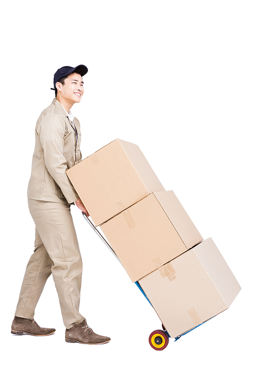 Delivery man moving luggage trolley with cardboard boxes on white background