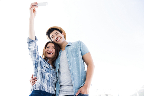 Happy young couple taking a selfie on smartphone outdoors