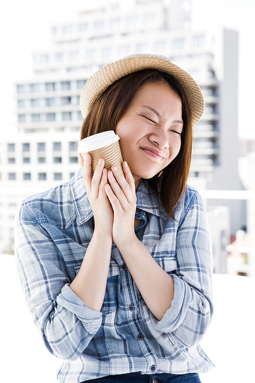 Young woman holding disposable cup outdoors