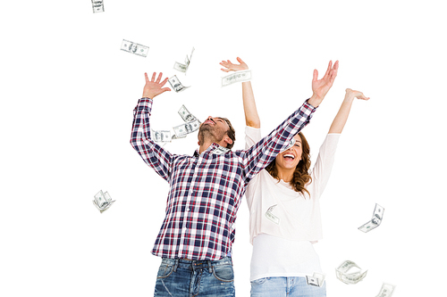Happy young couple throwing currency notes in air on white background