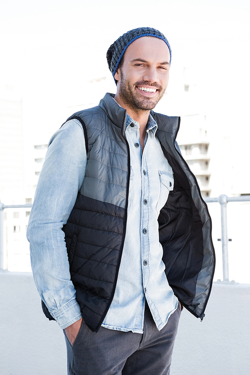 Portrait of confident young man wearing beanie hat and jacket