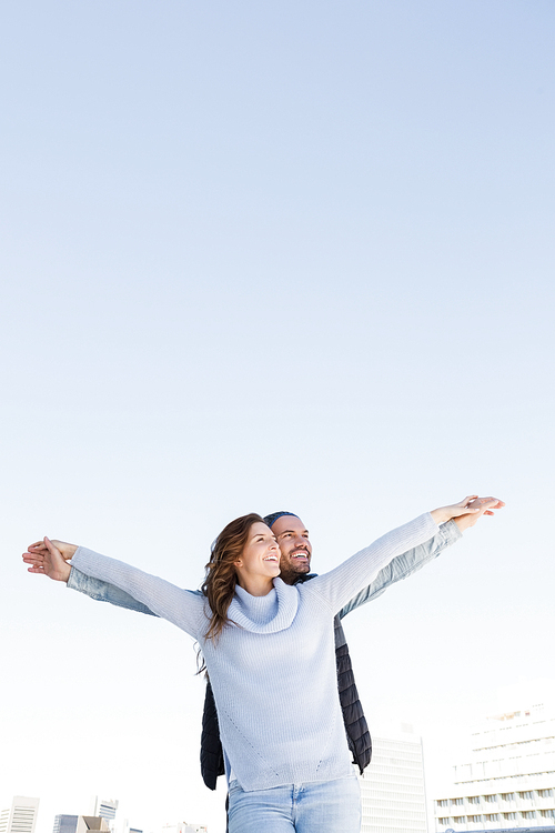 Happy couple standing with arms outstretched