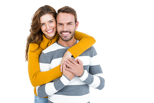 Portrait of happy young couple embracing each other on white background