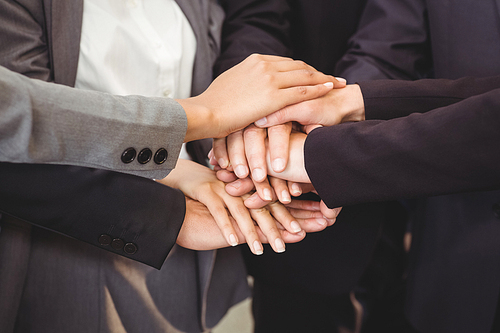 Close-up of businesspeople stacking hands in meeting at office